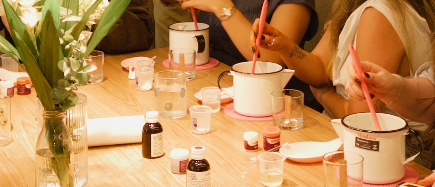 Convidadas mexendo a cera derretida com espátulas rosas